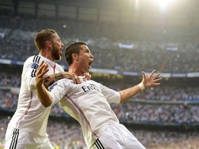 Real Madrid’s Cristiano Ronaldo (right) celebrates with Sergio Ramos after scoring during the UEFA Champions League semifinal at the Santiago Bernabeu stadium in Madrid on May 13, 2015. (AFP PHOTO/GERARD JULIEN)