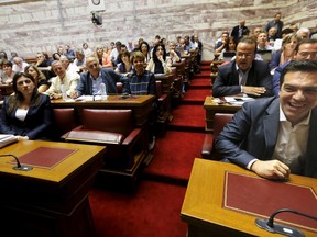 Greek Prime Minister Alexis Tsipras, right, laughs as Parliament Speaker Zoe Constantopoulou, left, looks on before a ruling Syriza party parliamentary group session in Athens, Greece July 15, 2015. (REUTERS/Yannis Behrakis)