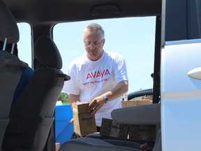 SAMANTHA REED/FOR THE INTELLIGENCER
Avaya employee Murray Gibb loads product into a minivan Wednesday afternoon. Avaya and United Way collaborated to hold a community drive-thru sale to raise money for the non-profit organization.