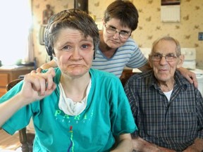 Jennifer James is severely autistic and wears headphones to block distracting sound. Her sister, Caroline, centre, served as Jennifer's caregiver until Jennifer went into a residential facility last fall after the death last year of their father, Arnold, right. (Postmedia Network)