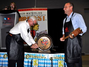 Mayor Matt Brown (right) and Hugh Mitchell, CEO of Western Fair District, tap a keg at a news conference in London Ont. July 15, 2015. They helped announced that the Kitchener-Waterloo Oktoberfest was expanding to London in the fall. CHRIS MONTANINI\LONDONER\POSTMEDIA NETWORK