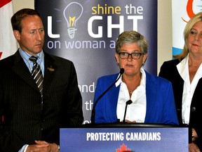 Justice Minister Peter McKay (left) listens with London North Centre MP Susan Truppe (right) as Megan Walker, executive director of the London Abused Women’s Centre, speaks about a funding announcement in London Ont. July 15, 2015. CHRIS MONTANINI\LONDONER\POSTMEDIA NETWORK