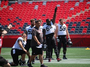 Members of the Ottawa RedBlacks offensive line whoop it up during practice at TD Place Wednesday, July 15, 2015. (Tim Baines/Ottawa Sun)