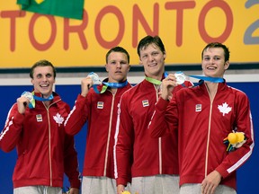 Canadian team members, from left, Santo Condorelli, Karl Krug, Evan Van Moerkerke and Yuri Kisil smile as they hold their medals after a second place finish in the men's 4x100 freestyle swimming event at the Pan Am Games in Toronto on Tuesday, July 14. (THE CANADIAN PRESS/Frank Gunn)