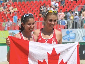 Beach volleyball players Taylor Pischke and Melissa Humana-Paredes hold up a Canadian flag in this 2013 file photo. (QMI Agency)