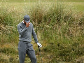Tiger Woods prepares to take a shot from the rough on the fifth hole during the first round of the British Open at the Old Course, St. Andrews, Scotland, on Thursday, July 16, 2015. (Peter Morrison/AP Photo)