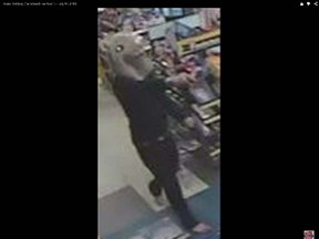 A man is seen in security video footage robbing a convenience store in Barrie, wearing a mouse head. (YouTube screenshot)