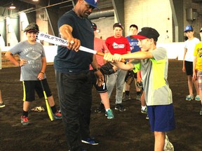 Former Toronto Blue Jay and two-time Gold Glove award recipient, Jesse Barfield, shows Brayden Taylor, 11, the correct batting stance at the REACH Centre on July 14. Barfield was in town for the third annual Clinton Minor Baseball camp. (Laura Broadley/Clinton News Record)