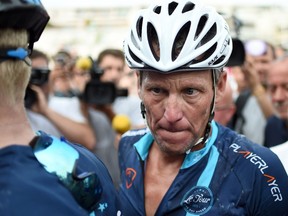 US cyclist Lance Armstrong looks on upon his arrival in Rodez, southwest France, after riding a stage  of The Tour De France for a leukaemia charity, a day ahead of the competing riders, on July 16, 2015. (AFP/STEPHANE DE SAKUTIN)