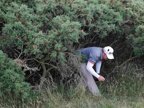 J.B. Holmes walks out from a bush after retrieving his ball on the 15th hole during the first round of the British Open on the Old Course in St. Andrews, Scotland, on Thursday, July 16, 2015. (Paul Childs/Reuters)