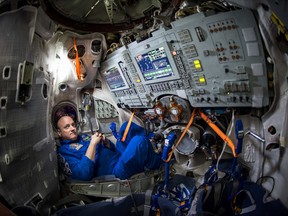 In this Wednesday, March 4, 2015 photo provided by NASA, astronaut Scott Kelly sits inside a Soyuz simulator at the Gagarin Cosmonaut Training Center (GCTC) in Star City, Russia. On Thursday, July 16, 2015, a piece of space junk forced the three International Space Station astronauts, including Kelly, to seek emergency shelter in their Soyuz spacecraft docked to the station, in case they had to make a quick getaway. Bill Ingalls/NASA via AP