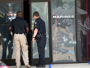 Police officers enter the Armed Forces Career Center through a bullet-riddled door after a gunman opened fire on the building Thursday, July 16, 2015, in Chattanooga, Tenn. Authorities say there were multiple casualties including the gunman. AP Photo/John Bazemore