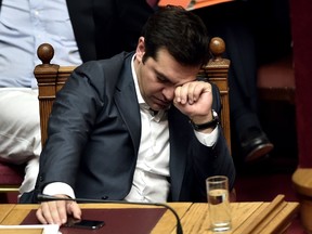 Greek Prime Minister Alexis Tsipras reacts during a parliament session in Athens on July 15, 2015. AFP PHOTO / ARIS MESSINIS