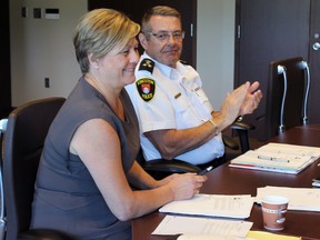 Kingston Police Deputy Chief Antje McNeely is congratulated by Police Chief Gilles Larochelle at the Police Services Board Meeting in Kingston, Ont. on Thursday July 16, 2015. Steph Crosier/Kingston Whig-Standard/Postmedia Network