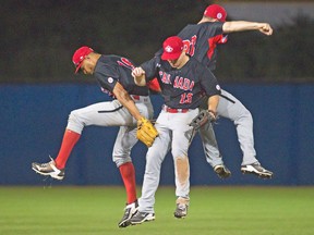 Canadian outfielders Tyler O’Neill, Tyson Gillies and Rene Tosoni leap into each other following last night’s 11-4 victory over Puerto Rico in Ajax. The win clinched first place for Canada with a meaningless game against the U.S., tonight. (Fred Thornhill, Canadian Press)