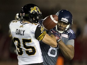 Hamilton Tiger-Cats' Mike Daly (35) tries to dislodge the ball from Montreal Alouettes' Nik Lewis on July 16. (REUTERS/Christinne Muschi)