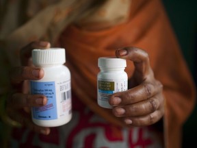 (FILES)A file picture taken on July 23, 2012 shows Indian HIV-infected women posing with her antiretroviral drugs at her home in New Delhi. New HIV infections have dropped by 35 percent from 2000 but the world needs to dramatically step up investment as well as access to treatment to roll back AIDS, UNAIDS said on July 14, 2015. There have been remarkable strides with the advent in 1996 of antiretroviral drugs, which suppress the human immunodeficiency virus (HIV), but a lot more needs to be done, the UN agency said. AFP PHOTO/ Andrew Caballero-Reynolds