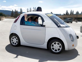In this May 13, 2015 photo, Teresa Favuzzi, of Sacramento, waves as she gets a ride in the new Google self-driving prototype car during a demonstration at Google's campus in Mountain View, Calif. (AP Photo/Tony Avelar)
