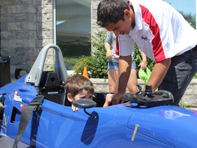SAMANTHA REED/For THE INTELLIGENCER
Three-year-old Connor Smith sits inside of a race car while driver Chase Pelletier answers questions, during the Trenton Military Family Resource Centre's promotional event Thursday afternoon.