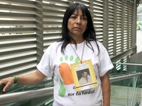 Luz Elena Galeano poses during a interview in Medellin, Colombia July 15, 2015. Galeano has been searching for her husband (whose photo seen hung around her neck) since 2008 in the Colombian city of Medellin. Colombian authorities have announced work will begin on July 27 to unearth what they say is the world's largest urban mass grave, located in a garbage tip in a sprawling mountainside slum known as Comuna 13 in western Medellin. Picture taken July 15, 2015. REUTERS/Fredy Builes