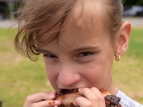 Alexandria Crowder samples ribs from Route 55 at the 2015 Tillsonburg Ribfest. (CHRIS ABBOTT/TILLSONBURG NEWS)