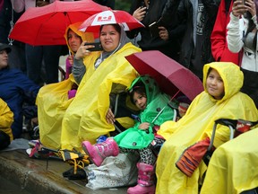 Parade fans wear rain gear for the 2015 K Days Parade in Edmonton, Alta., on Friday July 17, 2015. Perry Mah/Edmonton Sun/Postmedia