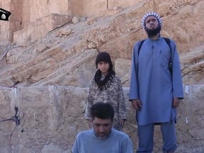 A screen grab image from video shows an ISIS soldier beheading a Syrian prisoner. Handout/Postmedia Network