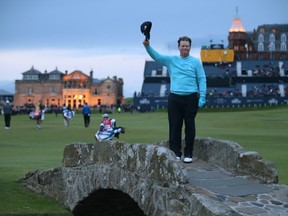 Tom Watson doffs his cap as he poses on the Swilcan Bridge during the second round of the British Open at the Old Course in St. Andrews, Scotland, Friday, July 17, 2015. (AP Photo/Peter Morrison)