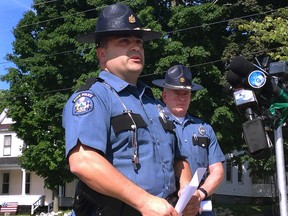 Maine State Police Lt. Sean Hashey, left, speaks Friday, July 17, 2015, outside the police department in Lincoln, Maine. Suspect Anthony Lord was arrested without incident Friday at a family member's home in Houlton, Maine, and faces charges in the shootings of several people overnight several towns in northern Maine. At right is State Police Maj. Chris Grotton. (AP Photo/Alanna Durkin)