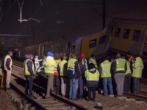 Emergency workers gather at the scene of a train collision at the Booysens train station near Johannesburg Friday July 17, 2015.  A commuter train crashed into another passenger train during rush hour Friday in South Africa's largest city injuring more than 300 people, an emergency services spokeswoman said. (AP Photo/Jacques Nelles)