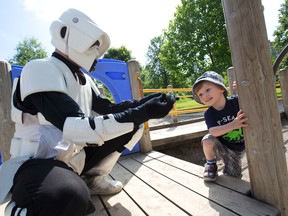 Brian MacKenzie, dressed as a Stormtrooper, and his son Aidan, 3, talk about a toy dinosaur in Gibbons Park in London. MacKenzie is a member of Dad Club London, a group that brings fathers, fathers-to-be, and those contemplating fatherhood together to share stories, lessons, and the other things fatherhood brings. (CRAIG GLOVER, The London Free Press)