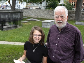Mariah Horner, founder and director with the Cellar Door Project and John Grenville, chair of the Lower Burial Ground Restoration Society, pose for a photo in the Lower Burial Ground at St Paul’s Anglican Church in Kingston, Ont. on Friday July 17, 2015.  As part of the Kick and Push Festival, the Cellar Door project will be a dramatically reanimating the Lower Burial Ground in the play, Tall Ghosts and Bad Weather which is opening Tuesday, July 21 at 9 p.m. Julia McKay/The Kingston Whig-Standard