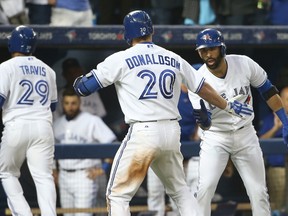 Josh Donaldson #20 of the Toronto Blue Jays is congratulated by Jose Bautista #19 after hitting a two-run home run in the fifth inning during MLB game action against the Tampa Bay Rays on July 17, 2015 at Rogers Centre in Toronto, Ontario, Canada. (Tom Szczerbowski/Getty Images/AFP)