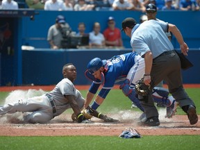 Blue Jays catcher Russell Martin (right) tags out Rays baserunner Tim Beckham (left) at the plate during fifth inning MLB action in Toronto on Saturday, July 18, 2015. Jon Blacker/THE CANADIAN PRESS