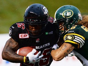 Ottawa Redblacks' Chevon Walker is tackled by Edmonton Eskimos' Aaron Grymes during first quarter CFL football action on Friday, July 17, 2015. 
THE CANADIAN PRESS/Sean Kilpatrick