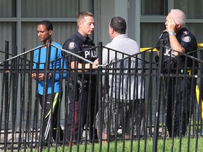 An unidentified man speaks with police outside a Thorncliffe Park apartment building July 18, 2015 after a child fell. (John Hanley/Special to the Toronto Sun)