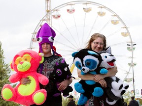 Anthoney Stevenson and Jaymie Protz head home with the stuffed animals they won on the K-Days midway, in Edmonton, Alta., on Friday July 17, 2015.