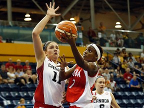 Cuba centre Marlene Cepeda shoots the ball against Canada’s Natalie Achonwa during Pan Am Games action at Ryerson Athletic Centre yesterday. Left, Canadian forward Miranda Ayim fights for a loose ball. (USA TODAY)