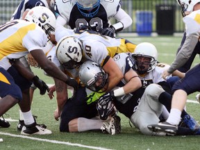 Sudbury Spartans running back Scott Smith is tackled by a gang of Sault Steelers including Matt Gauthier (40) and Colin Greenan (65) during Northern Football Conference action at James Jeroms Sports Complex in Sudbury on Saturday. Ben Leeson/The Sudbury Star/Postmedia Network