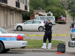 City Police forensic investigator makes a record of the scene of a homicide at 19 st and Northmount Dr. NW in Calgary, Ab., on Sunday July 19, 2015. Mike Drew/Postmedia Network