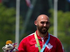 Canada's Jay Lyon stands on the podium after receiving his bronze medal in men's individual archery, at the Pan Am Games in Toronto, Saturday, July 18, 2015.(AP Photo/Rebecca Blackwell)