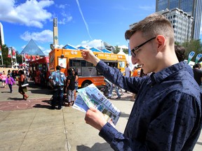 Reporter Kevin Maimann plans his food route at the Taste of Edmonton at Churchill Square on Sunday. Perry Mah/Edmonton Sun/Postmedia