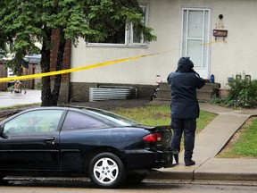 Police takes photos of a house on Hermitage area in Edmonton, Alta., on Friday July 17, 2015. A man suffered a gunshot overnight.