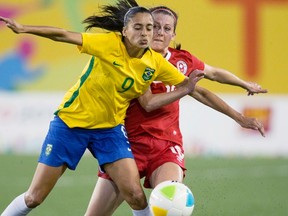 Canada’s Chelsea Stewart (right) and Brazil’s Andressa Alves battle for the ball during the first half of their Pan Am Games matchup in Hamilton last night. (The Canadian Press)