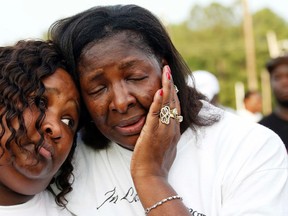 Frances Sanders, mother of Jonathan Sanders, right, hugs his sister Nicole Holloway, during a remembrance and rally for Jonathan Sanders in Stonewall, Miss., Sunday, July 19, 2015. Sanders died after a physical encounter with a white police officer on July 8, and had been riding in a two-wheeled buggy pulled by a horse. (AP Photo/Rogelio V. Solis)