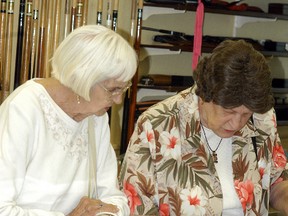 Mary Craig, left and Ida Debusschere look over some memorabilia during the Wallaceburg Adult Activity Centre's 40thanniversary open house held on July 8.