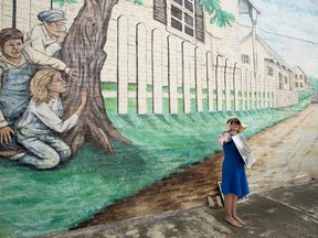 Sandy Smith stands in front of a mural of a scene from "To Kill a Mockingbird" while leading a walking tour in Monroeville, Alabama July 14, 2015. The southern hometown of author Harper Lee is celebrating the release of "Go Set a Watchman", Lee's first published novel in 55 years. REUTERS/Michael Spooneybarger