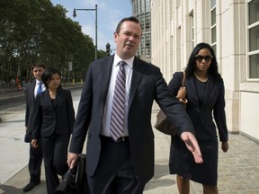 Edward O'Callaghan, a lawyer for Jeffrey Webb, makes his way past photographers as he departs the U.S. federal court with Webb's wife in Brooklyn, New York July.  (REUTERS/Stephanie Keith)