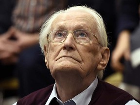 94-year-old former SS Sgt.Oskar Groening looks up as he listens to the verdict of his trial Wednesday, July 15, 2015 at a court in Lueneburg, northern Germany. (Tobias Schwarz/Pool Photo via AP)