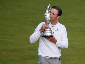 Zach Johnson kisses the trophy as he poses for photographers after winning a three-way playoff after the final round at the British Open at the Old Course, in St. Andrews, Scotland, on Monday, July 20, 2015. (Alastair Grant/AP Photo)